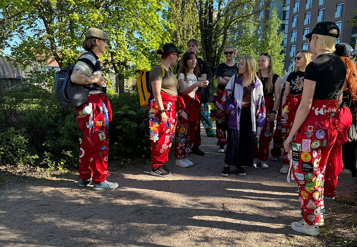 HUMAKOn opiskelijoita punaisissa halareissa puistossa